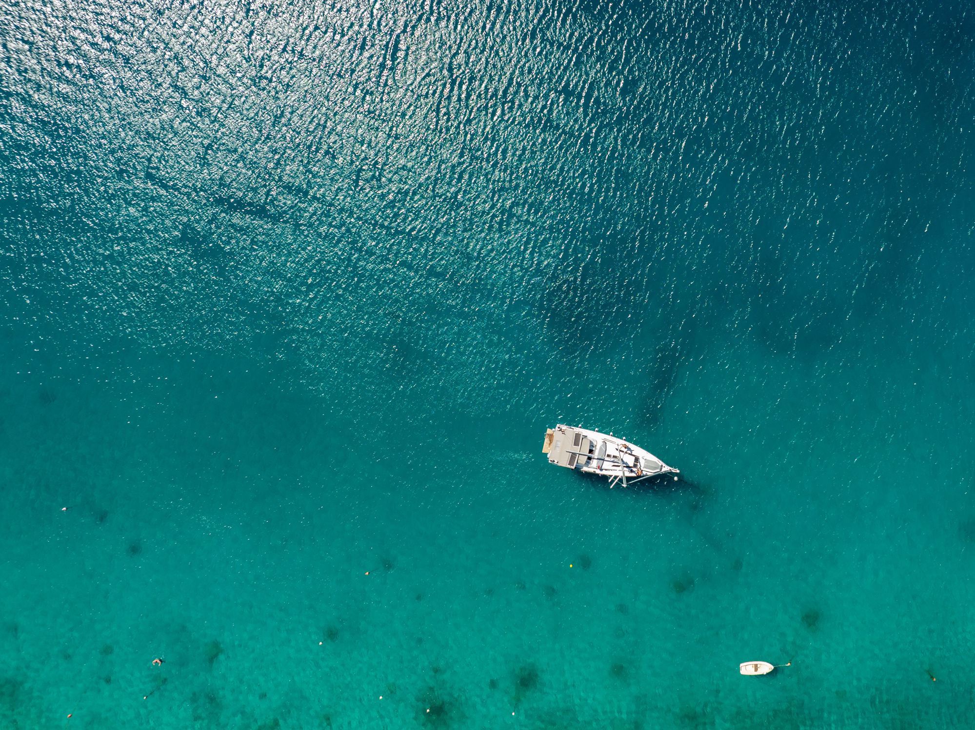 Sailboat floating in clear turquoise water